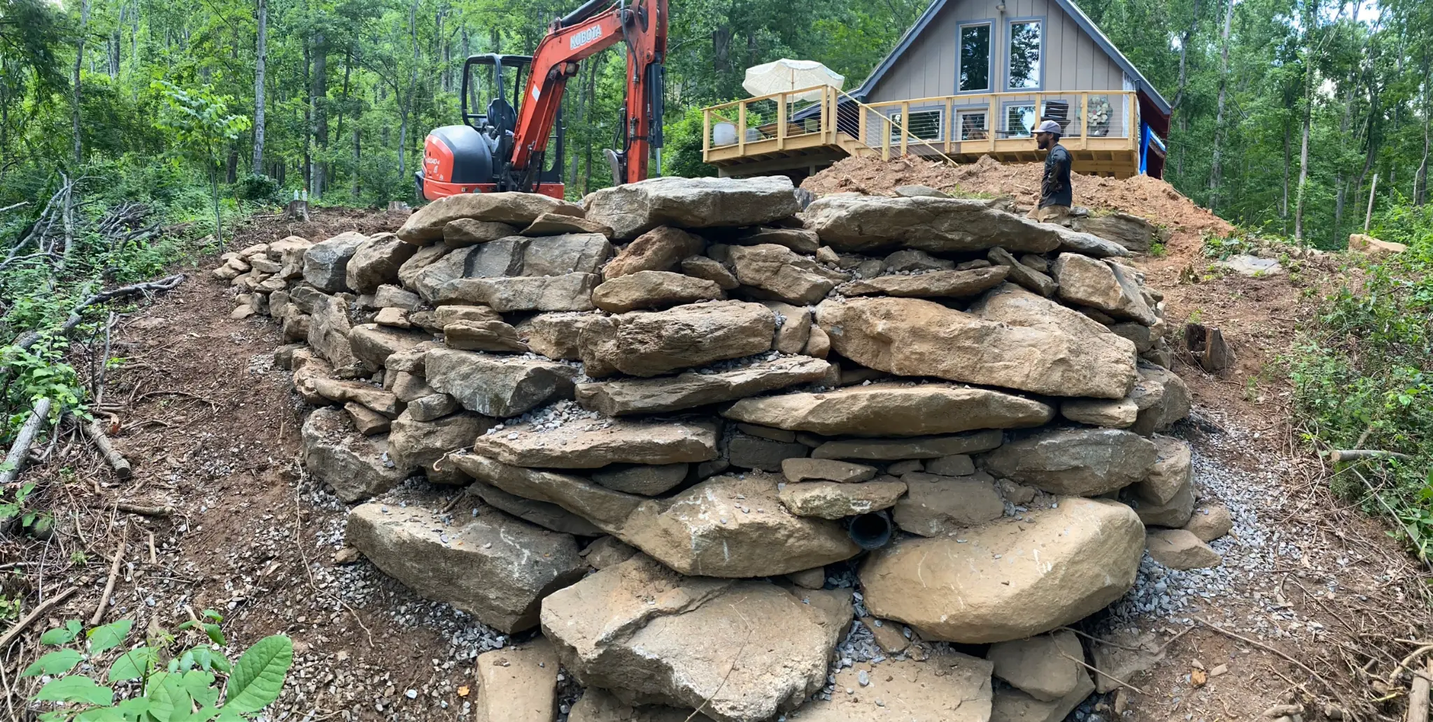 Stone retaining wall with excavator, WNC cabin